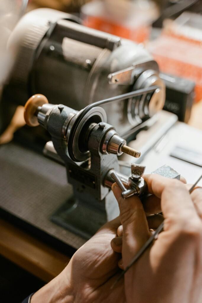 pexels-photo-8327969-8327969 Watchmaker uses lathe in meticulous precision work, showcasing craftsmanship and detail.
